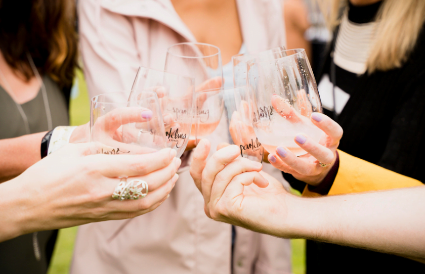 Group of friends clinking Sparkling Sydney wine glasses outside.