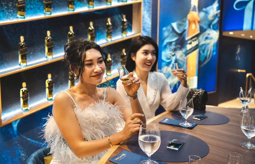 Two friends tasting whiskey at Johnnie Walker Pitt Street Mall Blue Room pop-up.