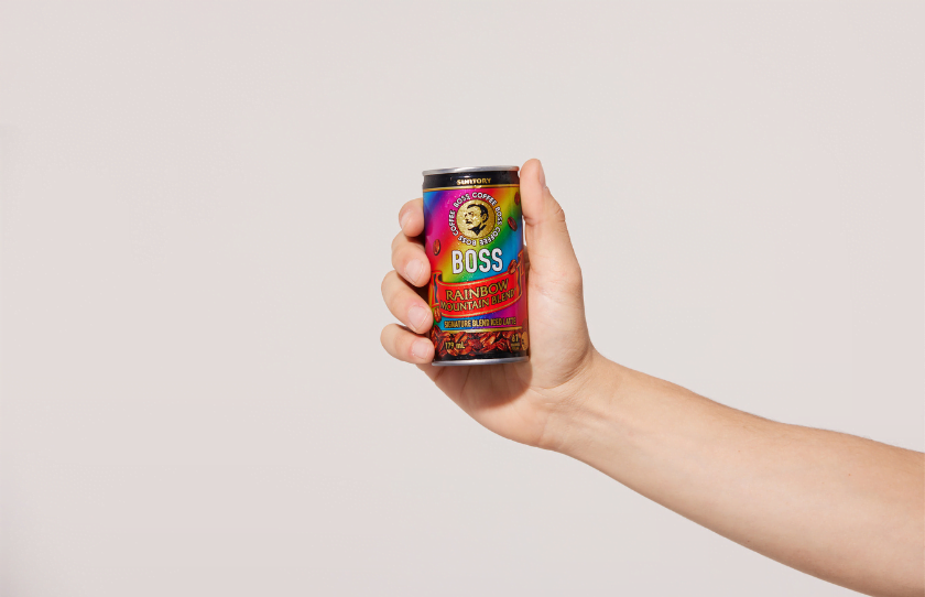 Caucasian hand holding can of Suntory BOSS Coffee Rainbow Mountain Blend.