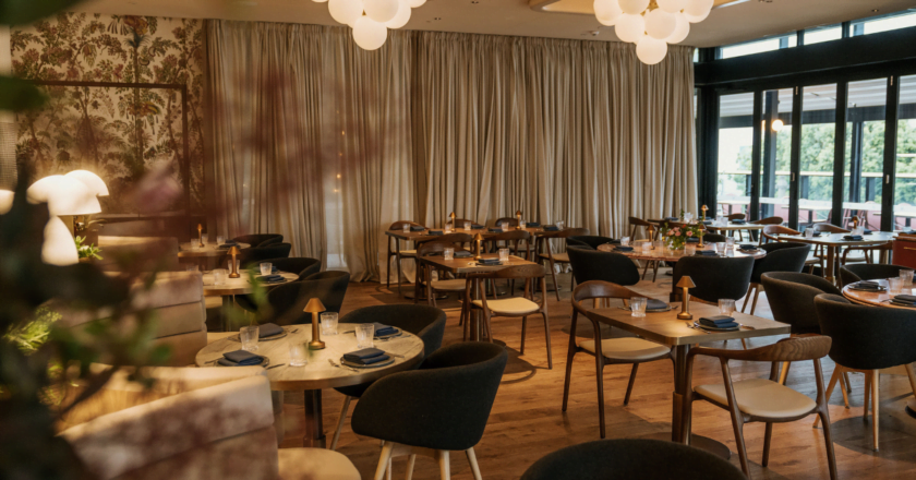 Grand dining room of Humphrey's Hotel & Hatch Restaurant featuring timber flooring and marble tables.