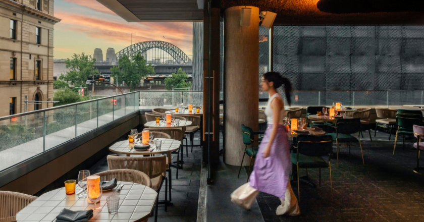 Waitress in purple against Sydney Harbour at Penelope's Circular Quay.
