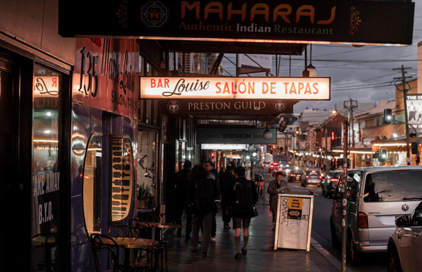 Bar Louise sign on the Enmore road at the evening time with people passing by
