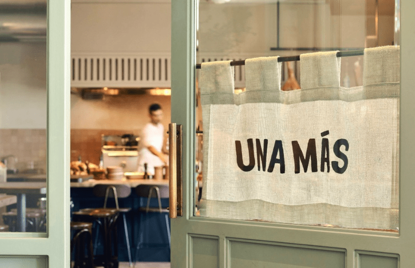 The main door to Una Mas, slightly open with the chef working on the background - Best European Venues in Sydney