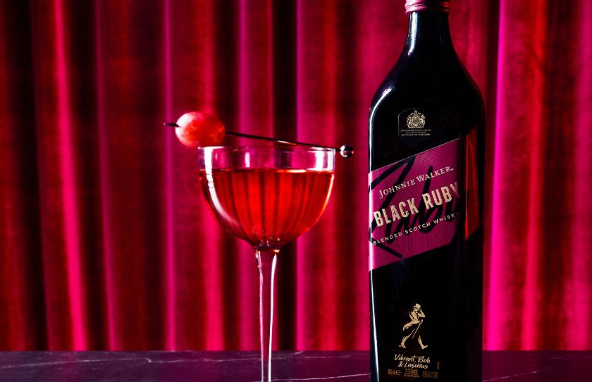 Image of johnny walker black ruby next to a cocktail mad ewith it in front of a red curtain - august drinks guide