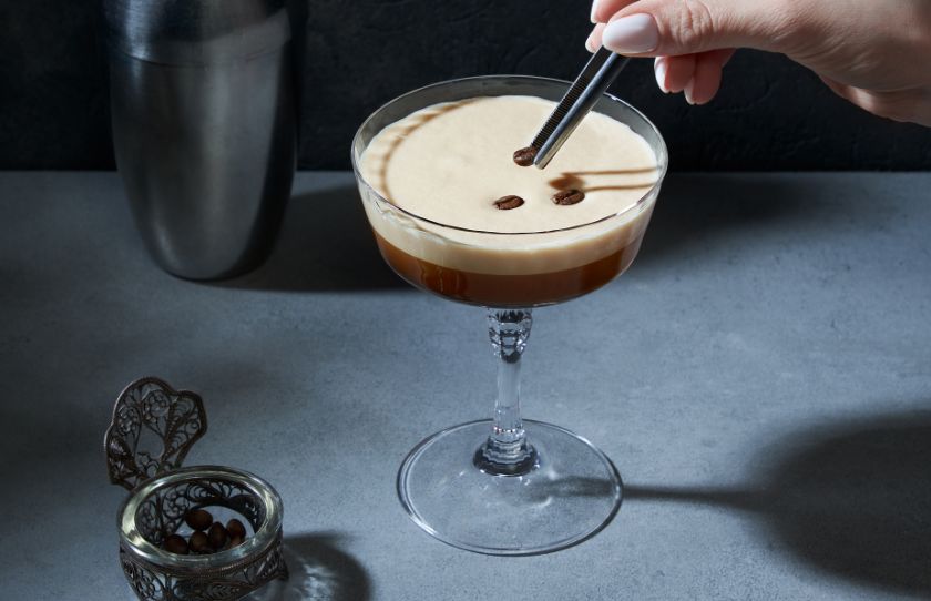 August Drinks Guide - Image of placing coffee beans on top of Espresso Martini made with Nemiroff de luxe vodka