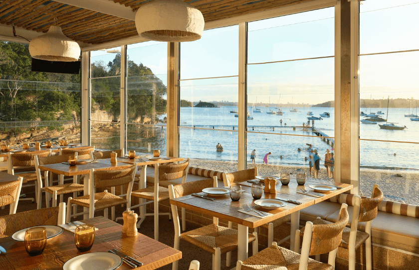 Sydney Restaurant Group 50% Off Set Menu - Ripples Little Manly. Tables set up inside with a view of Little Manly beach