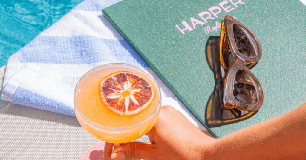Harper Rooftop Bar image of poolside cocktail, towel and sunglasses